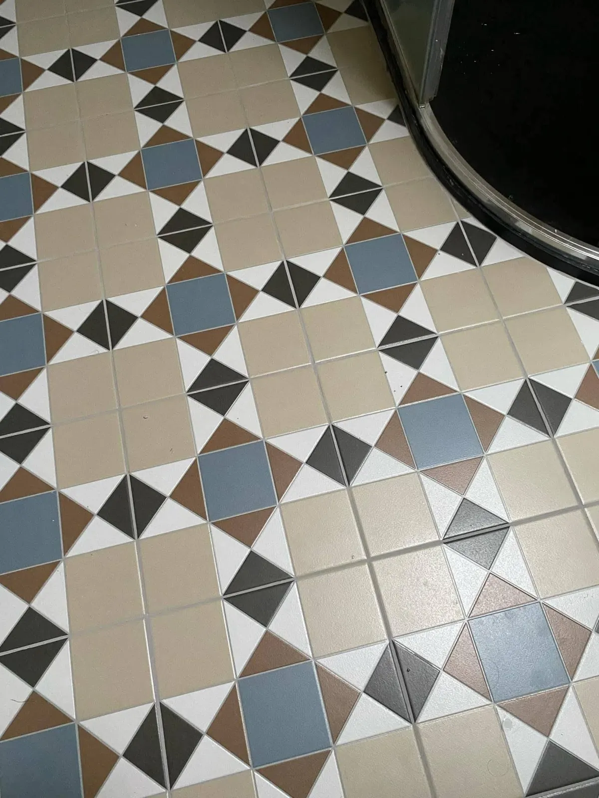 Patterned floor tiles by the shower